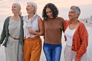 4 older women standing on a beach together